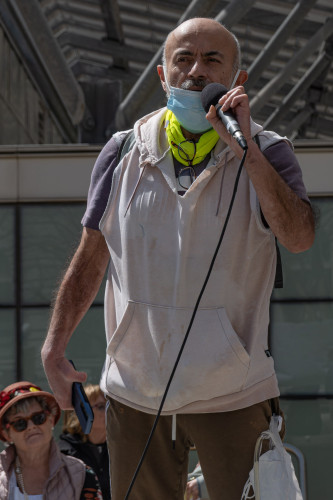 Latino man with protective mask for covid safety speaks on stage