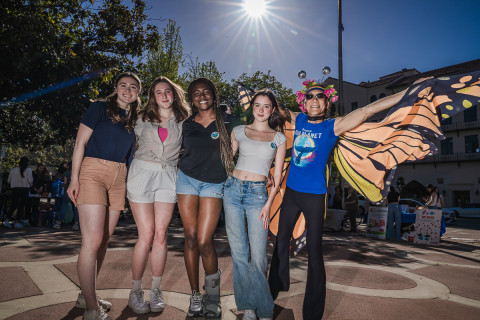 4 teenage girls and older man in butterfly costume smile 